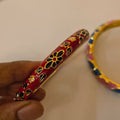 Scarlet red enamel bangle with black floral pattern and gold-tone trim