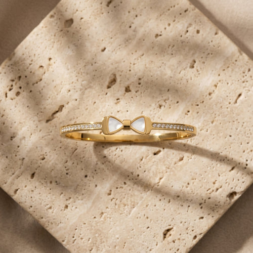 Pearl Bow Zircon Handcuff — gold-tone bangle with mother-of-pearl bow