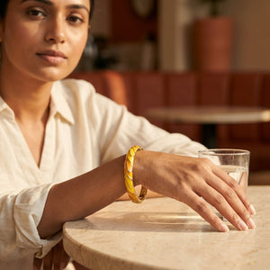Woman wearing Amber Wave Bangle at a cafe table