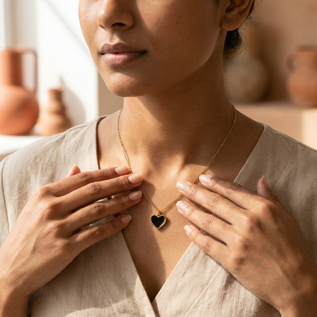 Woman holding Black Enamel Heart Necklace pendant with both hands