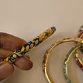 Navy blue enamel bangle with yellow floral pattern and crystal accents