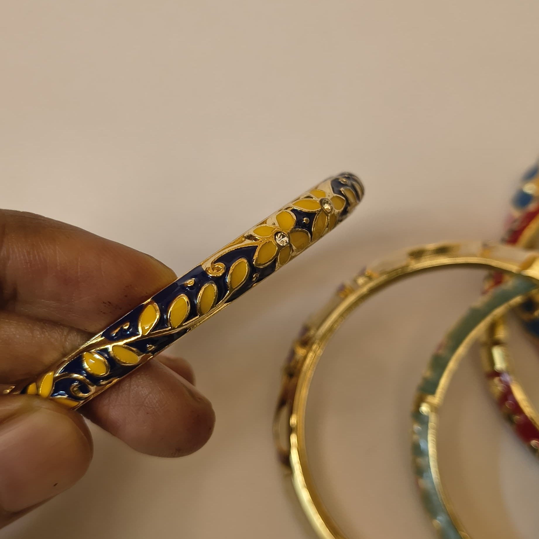 Navy blue enamel bangle with yellow floral pattern and crystal accents